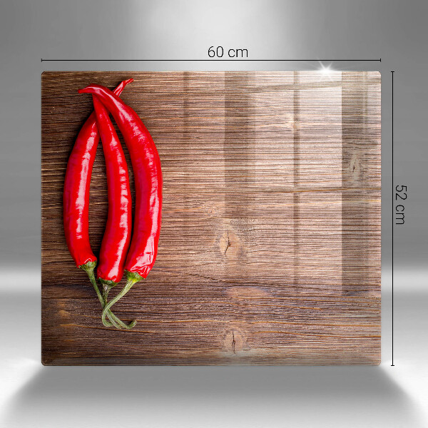 Chopping board glass Chili peppers on wood