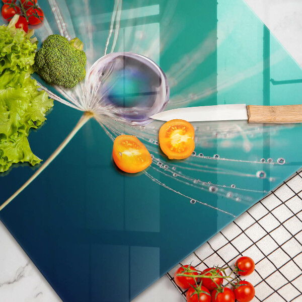 Chopping board glass Dew on a dandelion