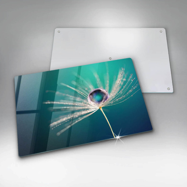 Chopping board glass Dew on a dandelion